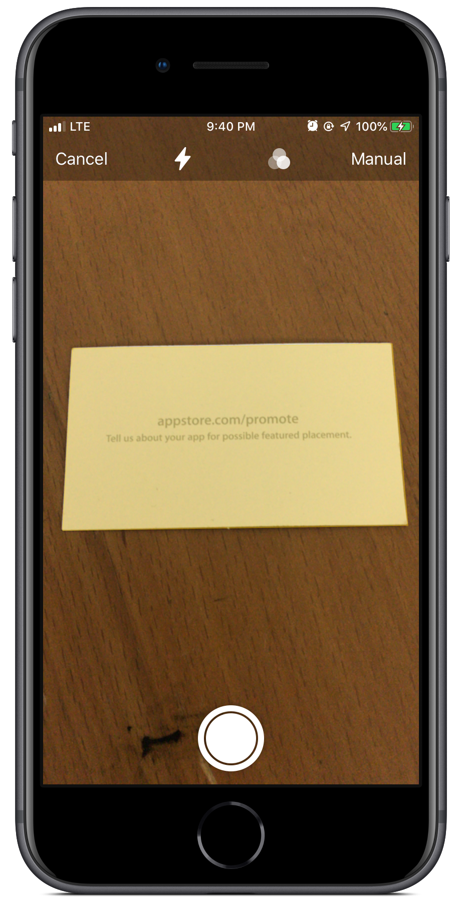 iPhone 8 displaying the iOS document scanner which is focused on a business card that says appstore.com/promote - tell us about your app for possible featured placement